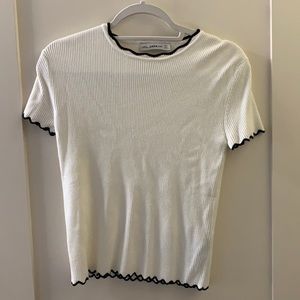 White ribbed top with black scallop edges